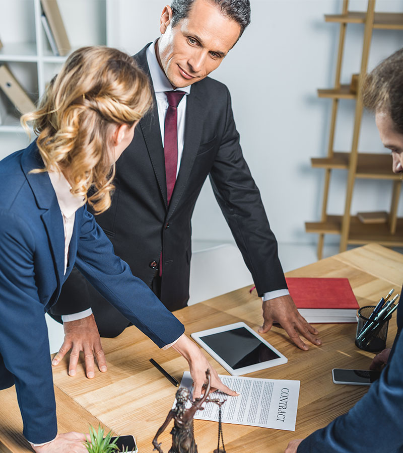 group of lawyers in suits discussing contract toge 76DHGLF